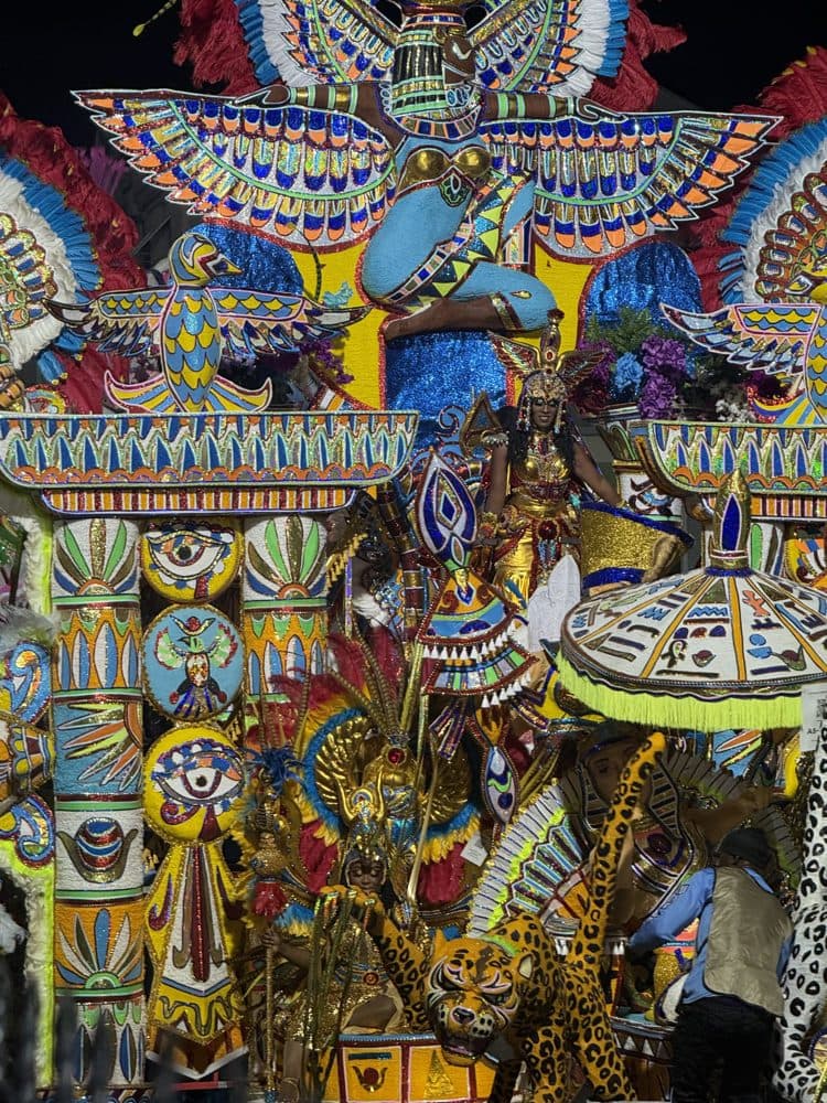 A Junkanoo parade float with feathered wings and bright mosaic costumes